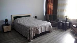 a bedroom with a bed and a chair in it at Hotel Newland in Chiatʼura
