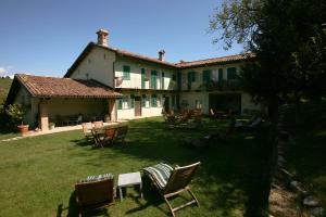 una casa con sedie e tavoli nel cortile di Cà San Ponzio country house & SPA a Barolo