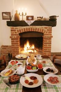 una mesa con platos de comida y una chimenea en Cà San Ponzio country house & SPA, en Barolo