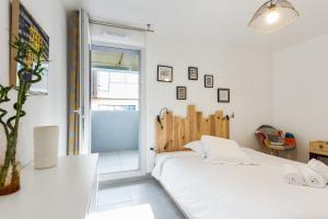 a white bedroom with a bed and a window at Luminescence Parc Marianne - Première conciergerie in Montpellier