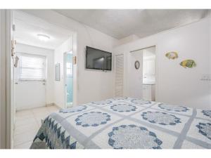 a bedroom with a bed and a flat screen tv at Belleview Gulf Condos in Clearwater Beach