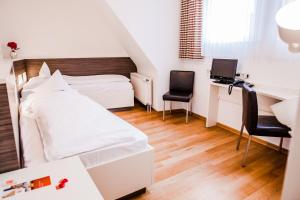 1 dormitorio con 1 cama y escritorio con ordenador en Hotel Martinihof en Münster
