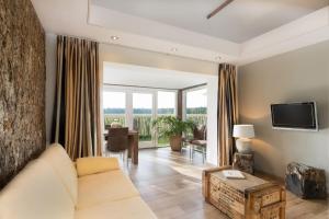 a living room with a couch and a tv at Bed & Breakfast de Zandhoef in Eersel