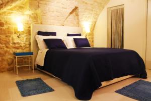 a bedroom with a large bed with a stone wall at Relais del Marchese in Turi