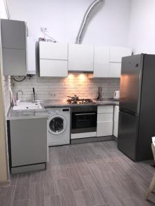 リヴィウにあるУютная квартира в центре Львоваの白いキャビネット、シンク、食器洗い機付きのキッチンが備わります。