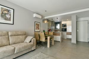 ein Wohnzimmer und eine Küche mit einem Sofa und einem Tisch in der Unterkunft Oasis Beach IX PuntaPrima in Torrevieja
