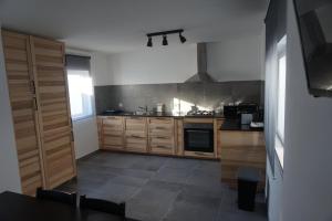 a kitchen with wooden cabinets and a stove at Trivial Pisão - Casa de Férias, para a sua Família in Raposeira