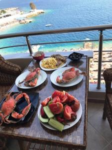 a table with four plates of crabs and french fries at Royal King and Queen apartment for Luxury Life in Sarandë
