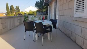 een tafel en stoelen op een terras bij Apartments Toncic in Lumbarda +30 foto's