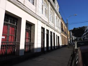 un edificio blanco con ventanas en una calle de la ciudad en Alojamiento centro Valparaìso, en Valparaíso
