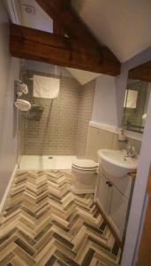a bathroom with a checkered floor and a toilet and sink at The Little George in Eccleshall