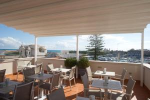 a restaurant with tables and chairs on a balcony at Le Dimore Del Re in Trani