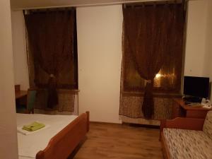 1 Schlafzimmer mit 2 Betten und 2 Fenstern mit Vorhängen in der Unterkunft Hotel Lamm in Pforzheim