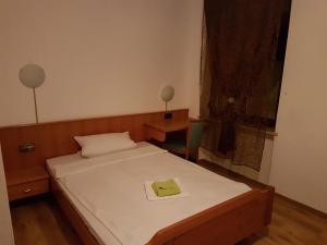 ein Schlafzimmer mit einem Bett mit einem grünen Handtuch darauf in der Unterkunft Hotel Lamm in Pforzheim