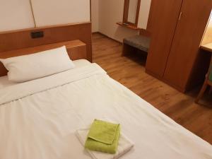 Zimmer mit einem Bett und einem grünen Handtuch darauf in der Unterkunft Hotel Lamm in Pforzheim