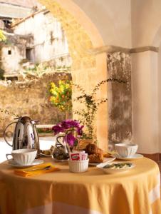 a table with a yellow table cloth with dishes on it at B&B Corte Catalana in Marigliano