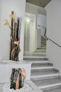 una hall con scale e un vaso con fiori di Hotel Nuovo Nord a Genova