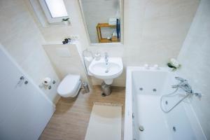 a bathroom with a sink and a toilet and a bath tub at Holiday home Privlaka/Zadar Riviera 8218 in Batalaži