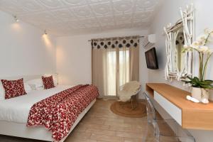 a bedroom with a bed and a desk and a window at Apollon Boutique Hotel in Parikia