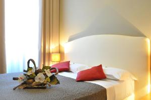 Hotel Nuovo Nord في جينوا: غرفة نوم بسرير ومخدات حمراء وبيضاء