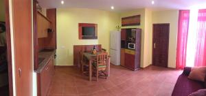 a small kitchen with a table and a refrigerator at Rosamar in Los Cristianos