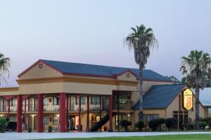 a hotel with a palm tree in front of it at Studio 6 Opelousas, LA in Opelousas
