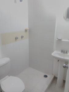 La salle de bains blanche est pourvue de toilettes et d'un lavabo. dans l'établissement Casa en Real Santa Fe, à Xochitepec