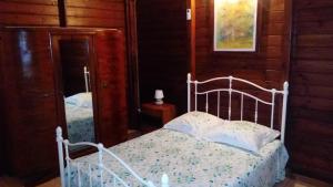 1 dormitorio con cama blanca y espejo en Habitation Fouyapen, en Sainte-Anne