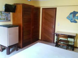 Zimmer mit einem Schreibtisch, einem Tisch und einem TV in der Unterkunft Flat para ate 4 pessoas - Frente a Praia dos Anjos in Arraial do Cabo