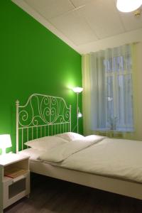 Dormitorio verde con cama y pared verde en Simple Babushka House, en San Petersburgo