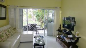 a living room with a couch and a sliding glass door at Rockley Golf Club, 2 bed 2 bath Pool, Tennis, Golf, Bar & Restaurant! in Bridgetown