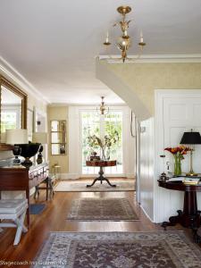 a living room with a staircase and a table at Stagecoach Inn in Goshen