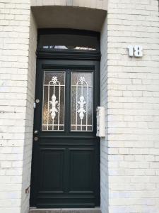 una puerta negra en un edificio de ladrillo blanco en Apartment KR18, en Ratingen