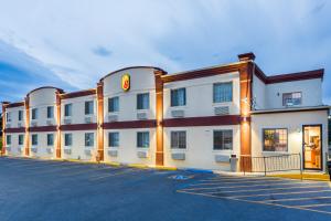 a large white building with a parking lot at Super 8 by Wyndham Douglas in Douglas