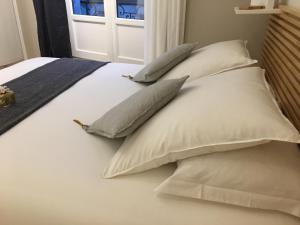 a bed with four pillows on it with a window at LOCKIA APPART-HÔTELS AUTOMATIQUES - Nantes Centre in Nantes