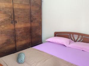 ネア・カリクラティアにあるSUNSET APpARTMENT MYKONOSのベッドルーム1室(ベッド1台付)、大きな木製キャビネットが備わります。