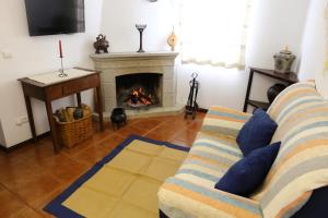 a living room with a couch and a fireplace at Casa dos Teares in Aldeia das Dez