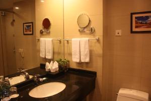 a bathroom with a sink and a toilet and a mirror at Super House International in Beijing