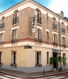 a large brick building with a sign on it at Hôtel Le Home Saint Louis in Versailles