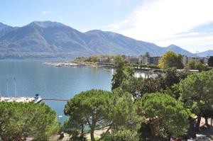 vistas a un lago con montañas en el fondo en Hotel Geranio Au Lac en Locarno
