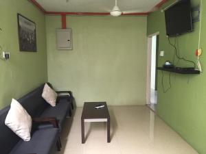 クアンタンにあるApple Boutique Homestayのソファとテーブルのあるリビングルーム