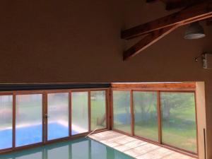 Habitación vacía con ventanas y piscina en Complejo Mil50 en San Carlos de Bariloche