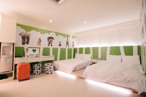 a bedroom with two beds and green and white stripes at Kiwi Express Hotel - Zhong Zheng Branch in Taichung