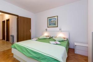 a bedroom with a large bed with green sheets at Apartment Doris in Banjole