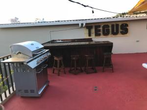 a piano and stools in front of a building at Palmira Hostel in Tegucigalpa