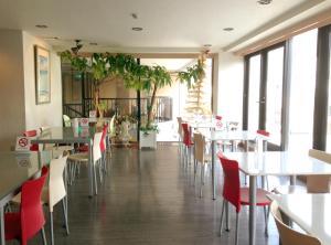 a dining room with tables and chairs and windows at Hotel Koga Hills (Former: Koga Ark Hotel) in Koga