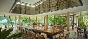 a dining room with a long table and chairs at PARKROYAL Penang Resort in Batu Ferringhi
