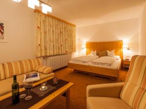 um quarto de hotel com uma cama e um sofá em Pension Kilian em Lech am Arlberg