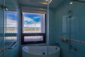 a bathroom with a bath tub and a window at C'est Mignon in Dongshan