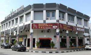 a large white building with cars parked in front of it at De Parkview Hotel in Ipoh